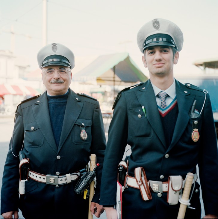 Two municipal police officers in uniform at Porta Palazzo market in Turin.