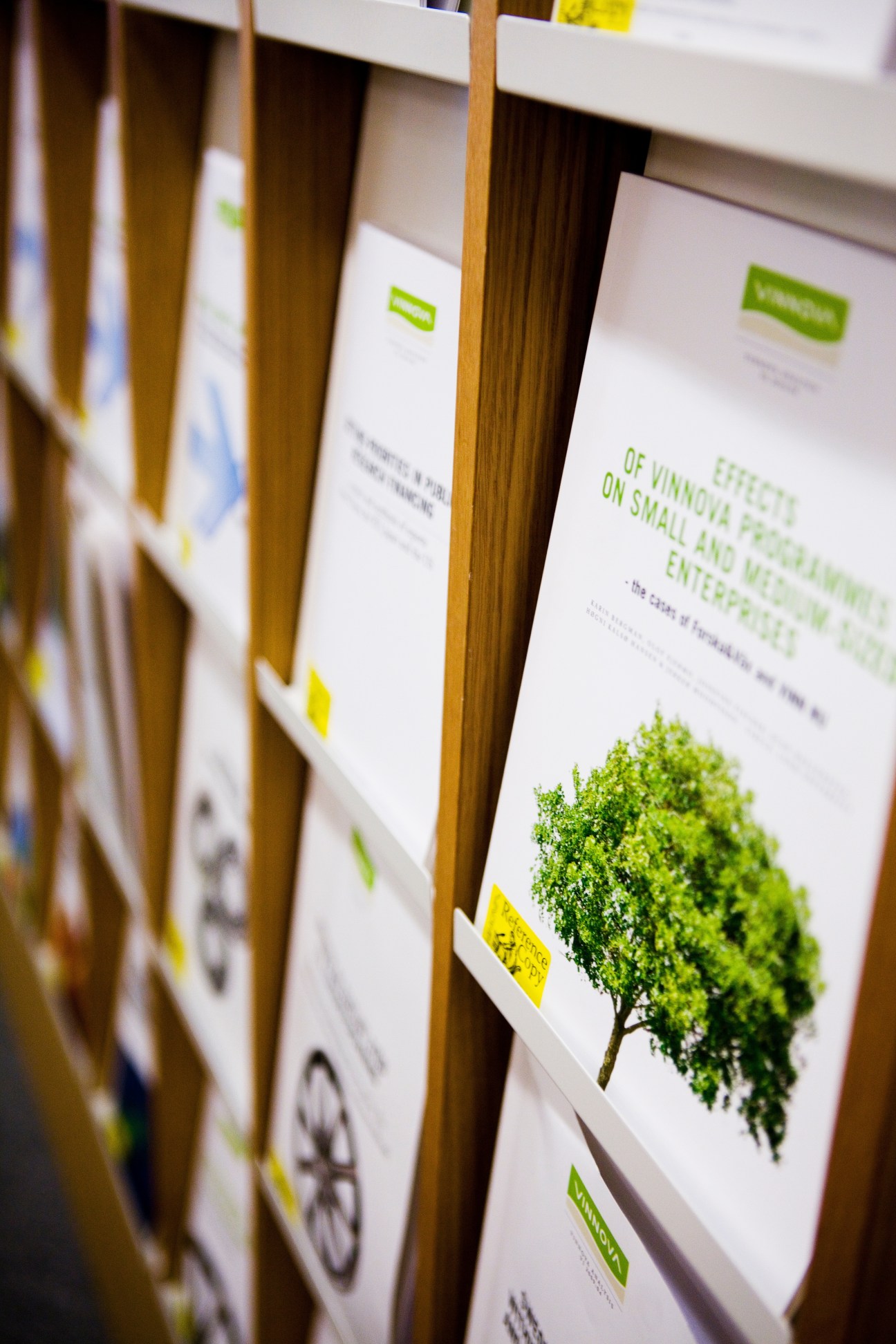 Stack of Vinnova reports with green branding and tree imagery on white covers.