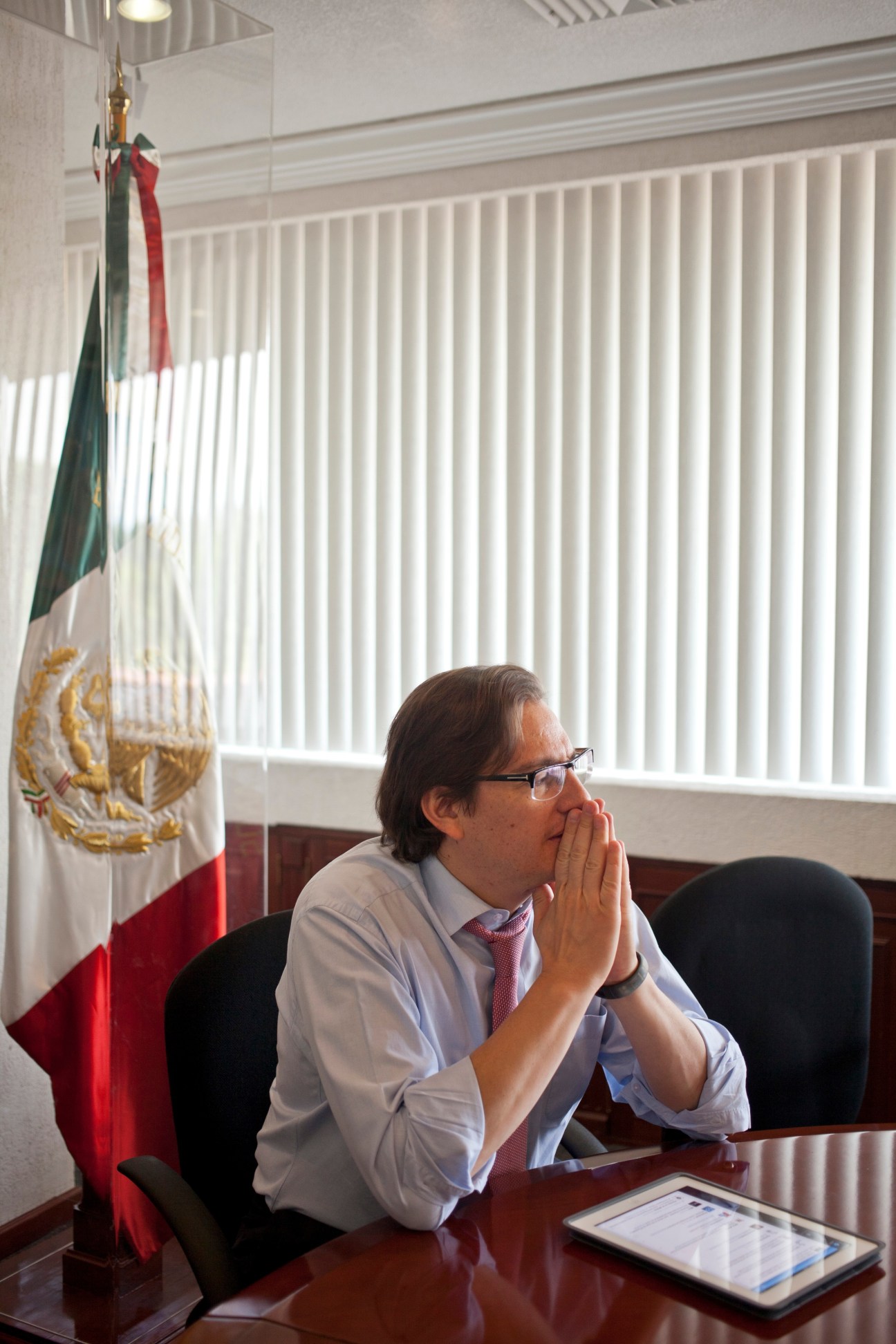 Salomón Chertorivski Woldenberg, economic development minister, sitting at desk with Mexican flag behind him.