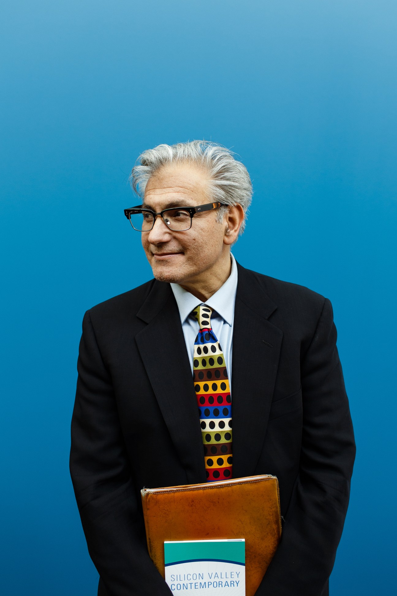Rick Friedman, founder of Silicon Valley Contemporary, wearing glasses and a patterned tie against a blue background.