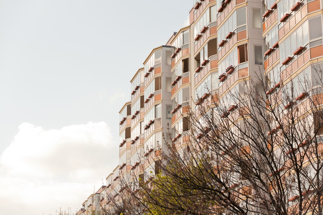Prefabricated high-rise apartment buildings with orange and white facade in Berlin's Marzahn district.