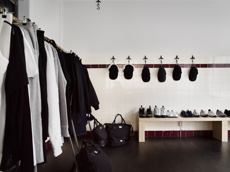 Spalwart clothing line displayed in a studio with tracksuits on a rail and shoes on shelves.