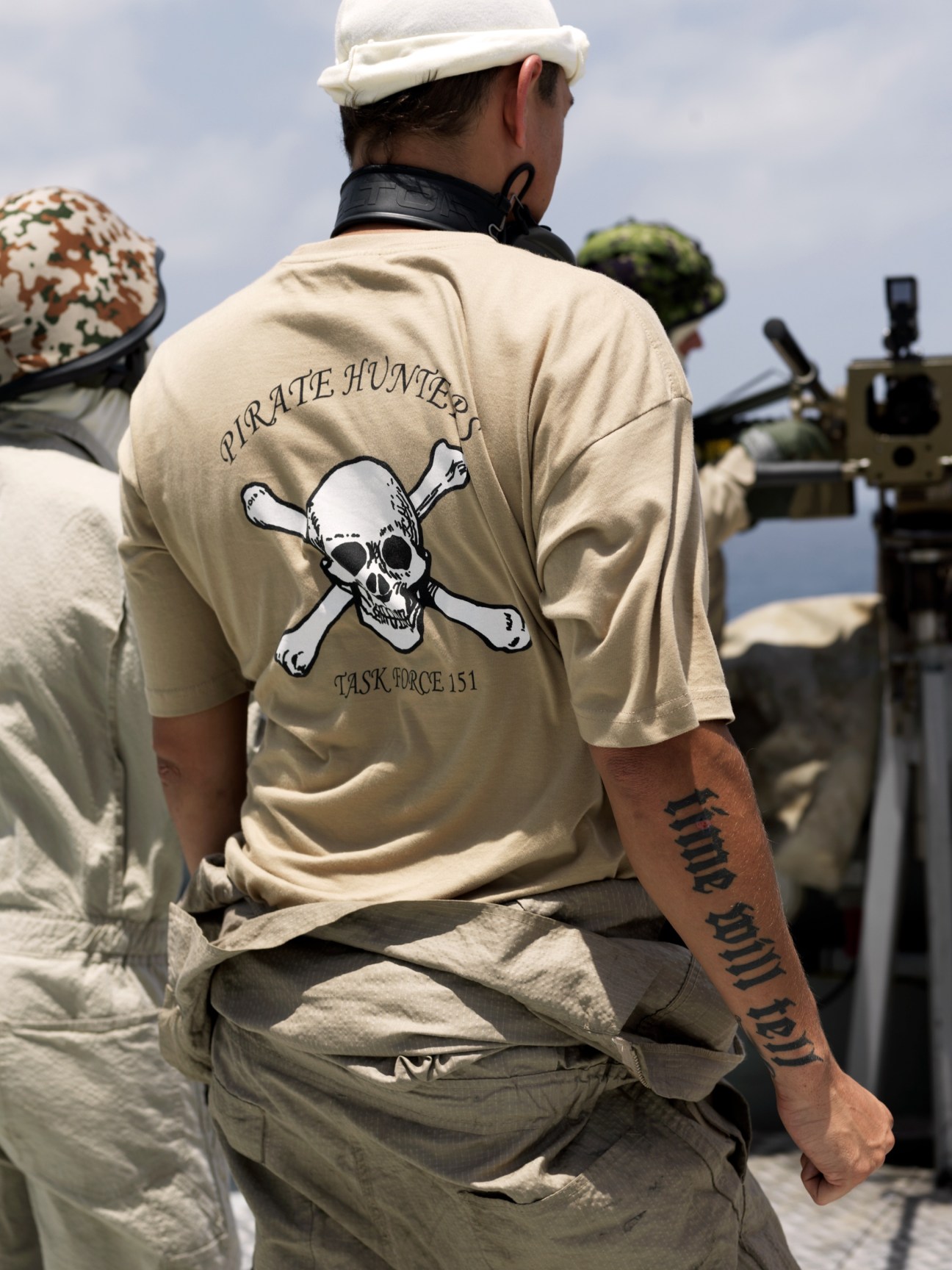 Danish Navy gunner Tai Toft Hansen wearing a 'Pirate Hunter Task Force 151' t-shirt with skull and crossbones design on the deck of HDMS Absalon.