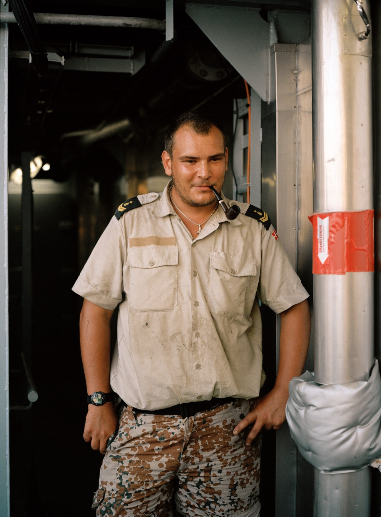 Danish Navy sailor Karsten Heise in uniform standing inside a ship corridor.