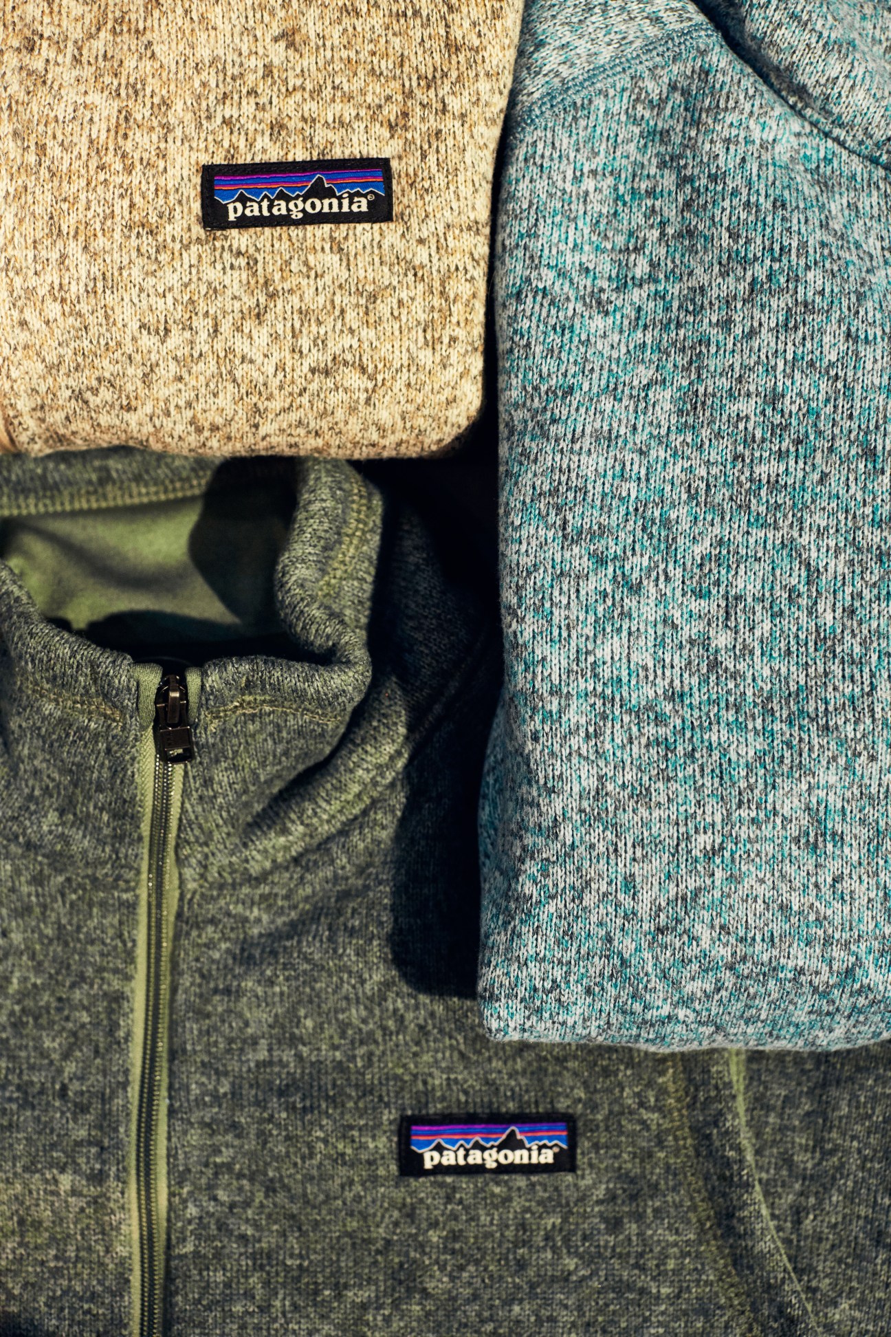 Patagonia Better Sweater collection featuring knit sweaters in cream, green and teal with branded labels.