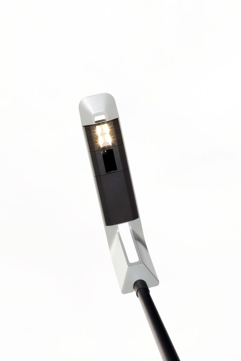 Eluminocity smart streetlamp with white top cap and black base displaying illuminated LED light against white background.