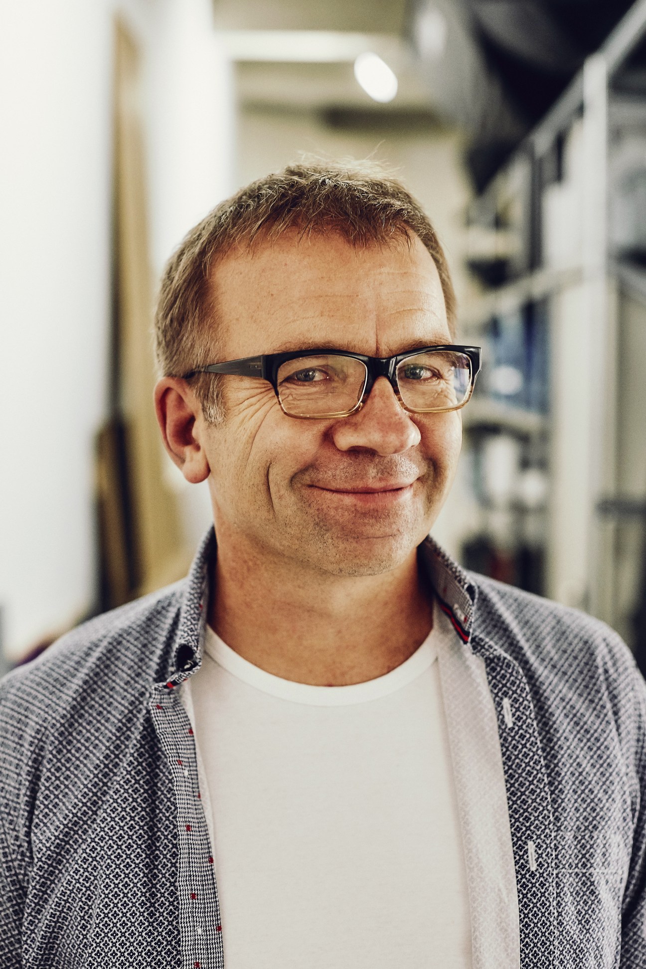 Hans Gerlach, co-founder of Food und Text studio in Munich, wearing glasses and a grey jacket.