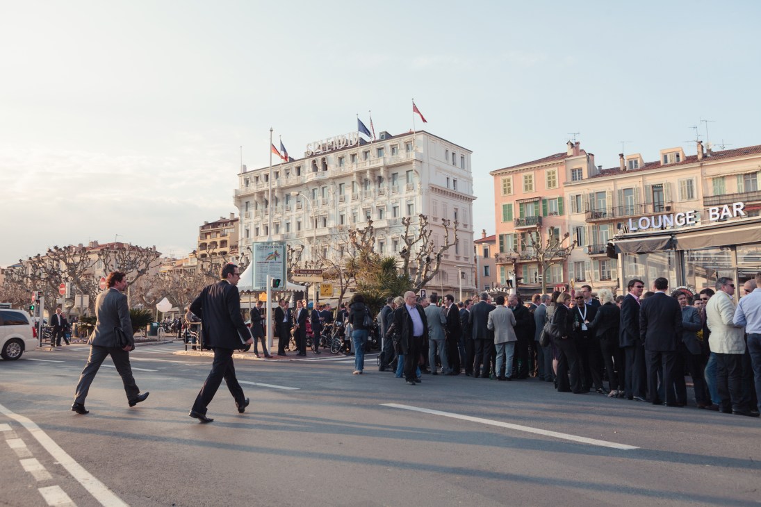 Businesspeople gather on Cannes' Promenade de la Croisette during MIPIM property market.
