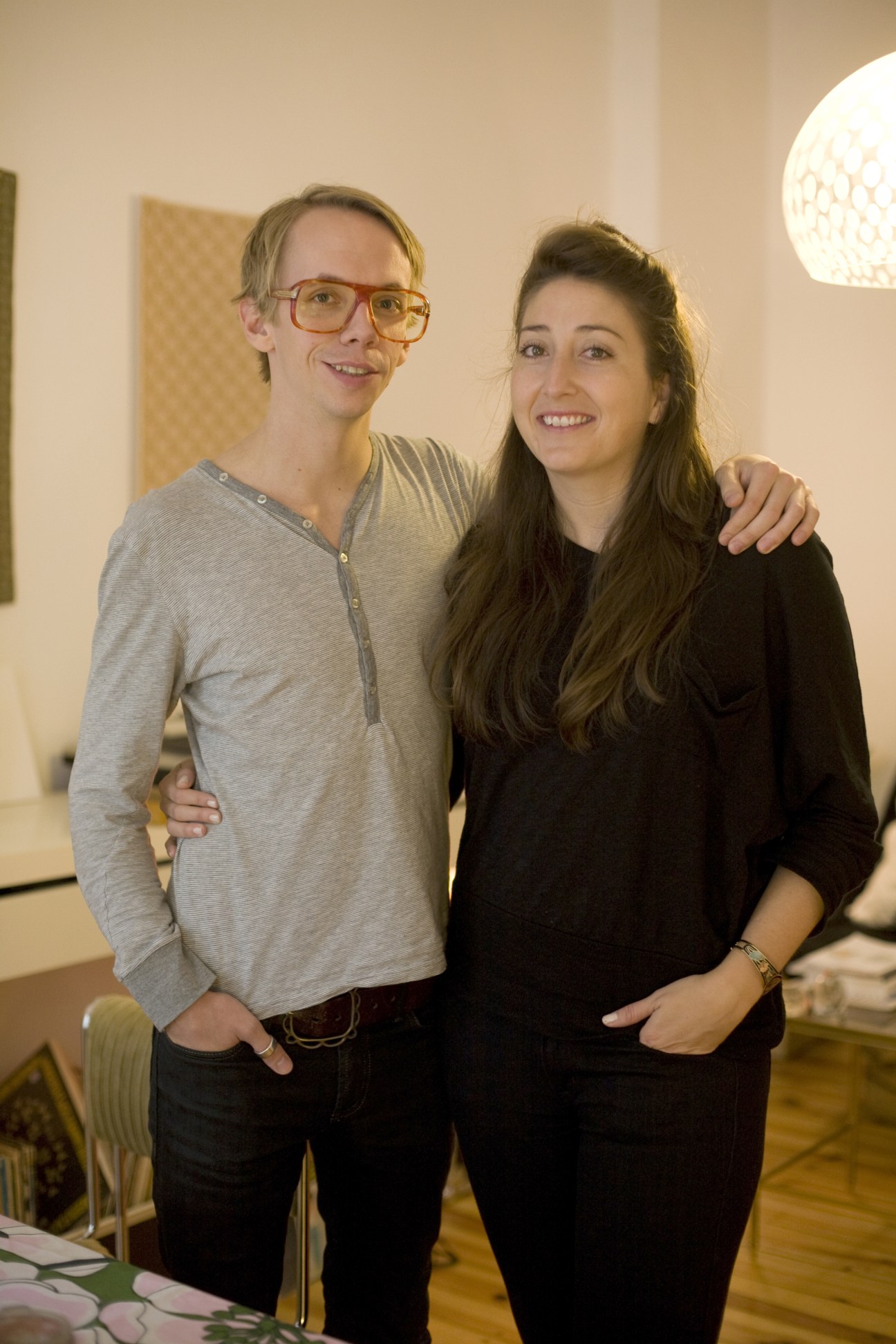 Magnus Bjerk and Britney Anne Majure stand together smiling in an interior space with modern lighting.