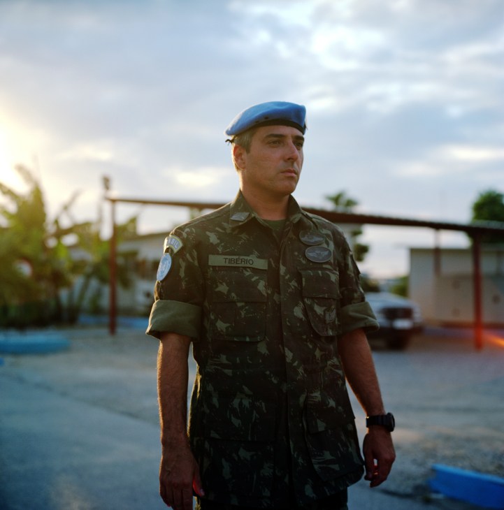 Lieutenant Colonel Márcio Tibério in camouflage uniform and blue UN beret standing at a military base in Haiti.