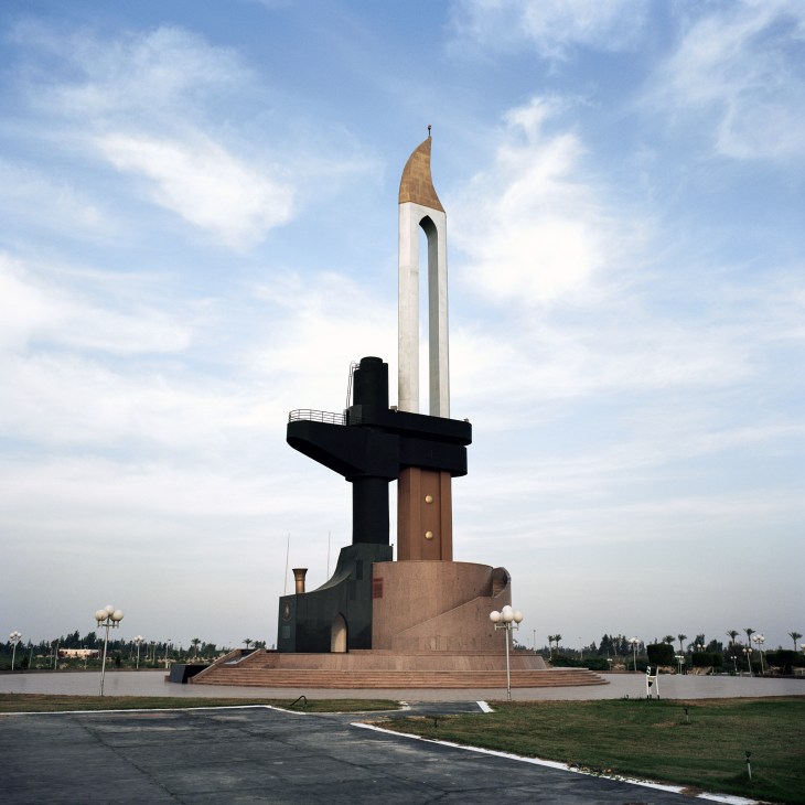 Monumental statue featuring a white tower with bronze bayonet and black cross at its base in Ismailia, Egypt.