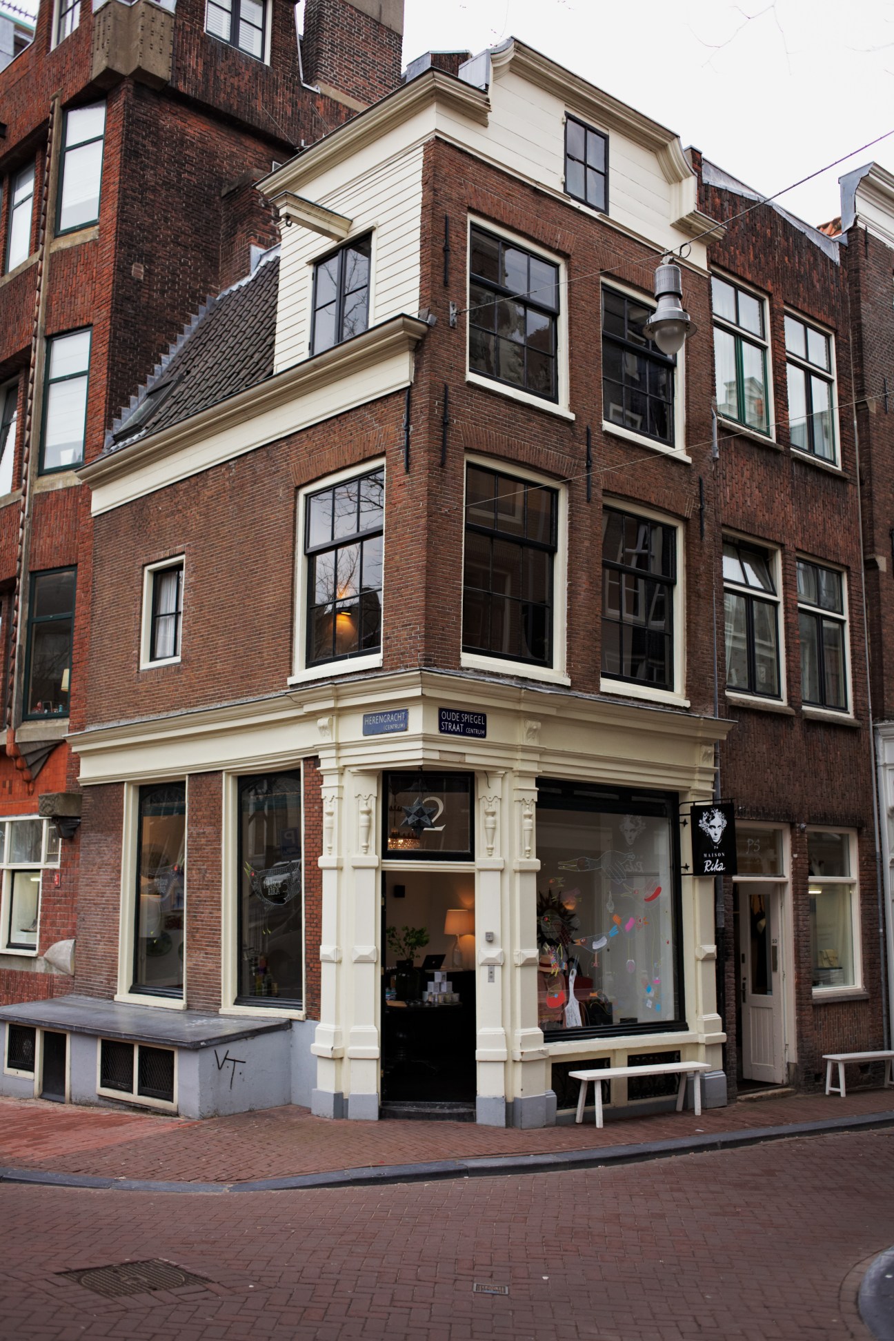 Traditional Dutch corner building with brick facade and ground-floor boutique storefront, Maison Rika in Amsterdam.