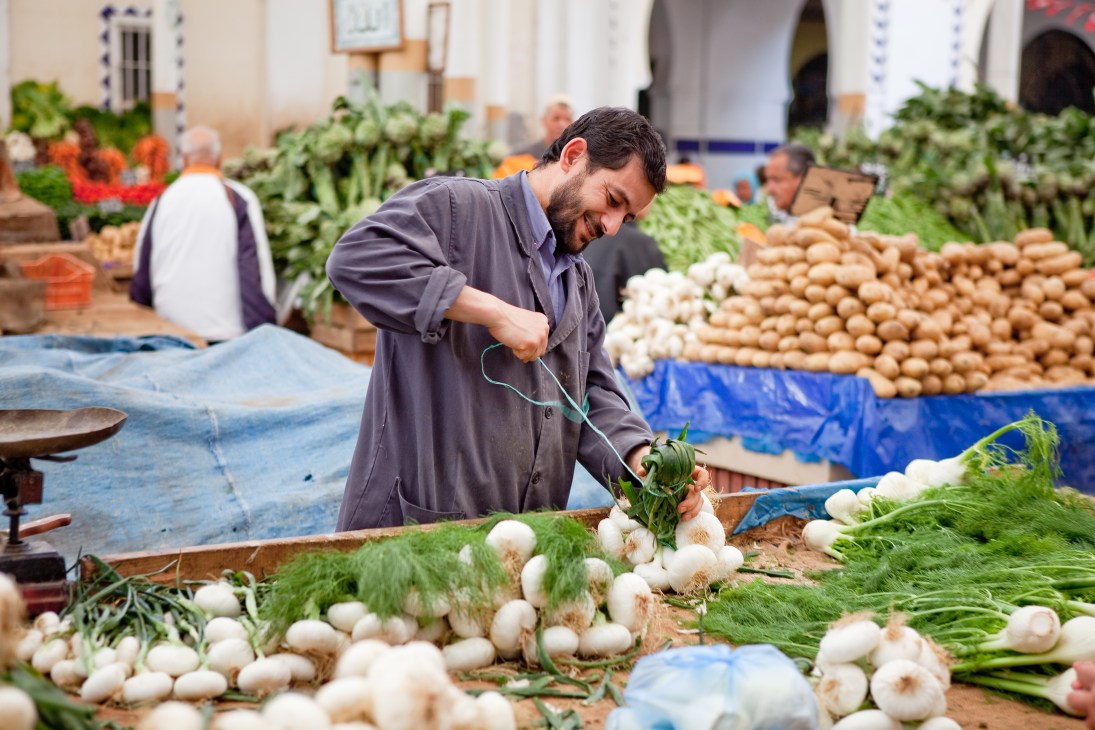 A vendor arranges white onions at a market stall in central Tunis