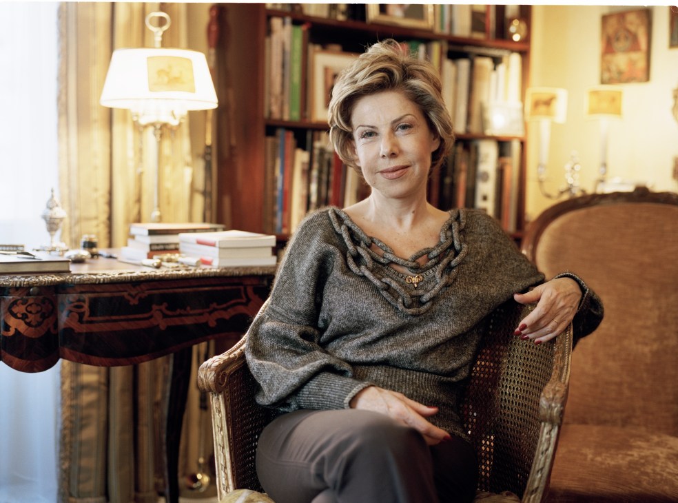 Author Myriam Antaki sits in her study surrounded by bookshelves, wearing a gray sweater.