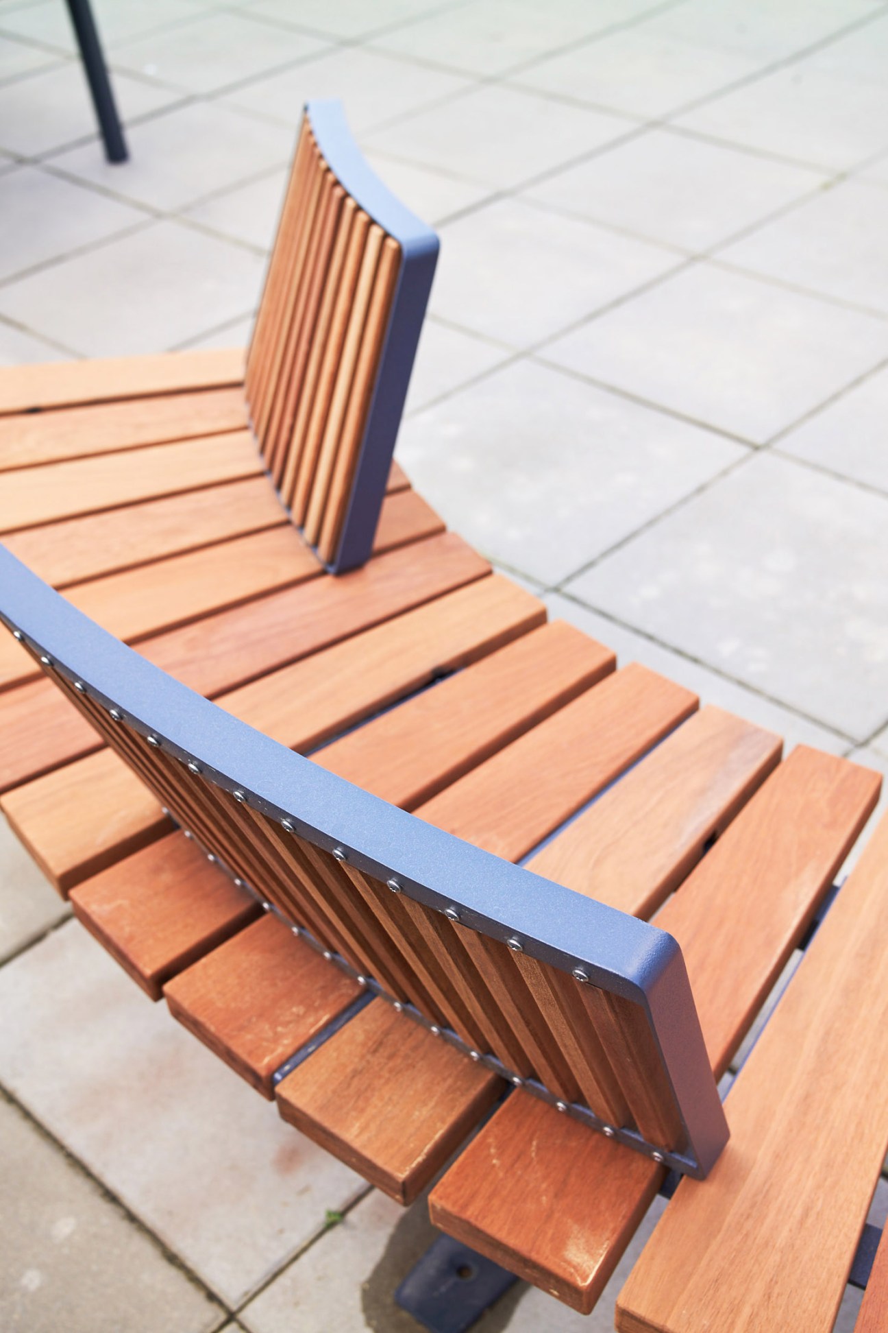 Mmcité bench with blue backrest and wooden slats on white tile floor