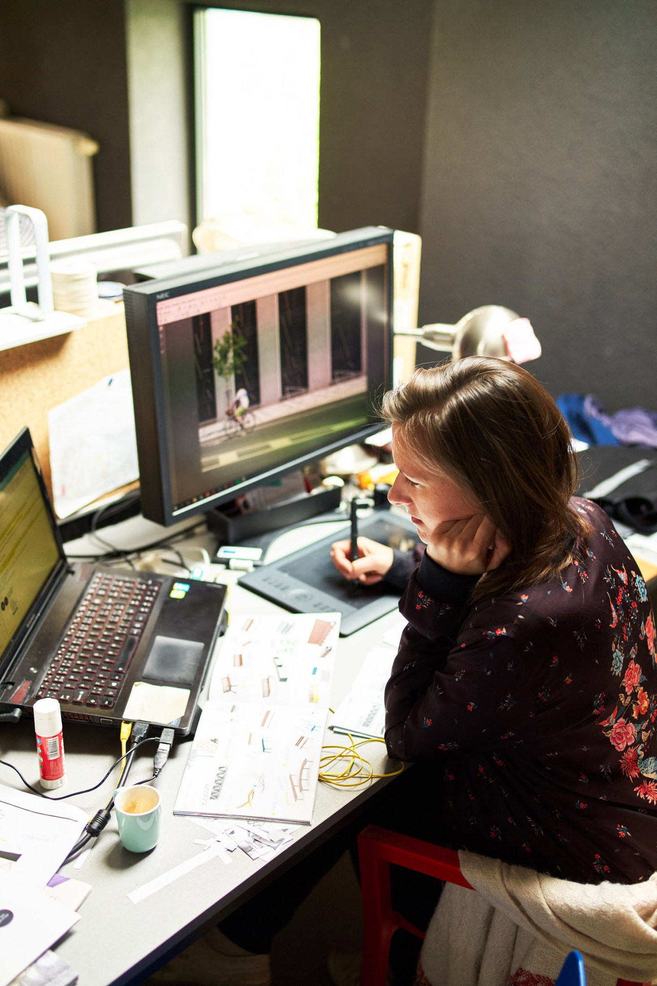 Woman working at computer displaying design software in Mmcité's design and development office.