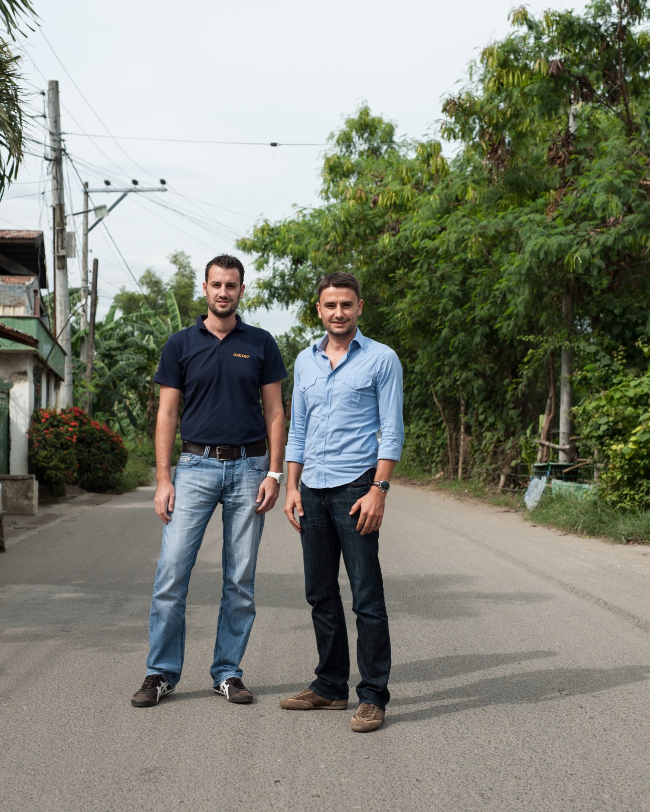 Hervé Lampert and Vince Lampert, managing director, stand on a rural road lined with lush vegetation at Dedon.