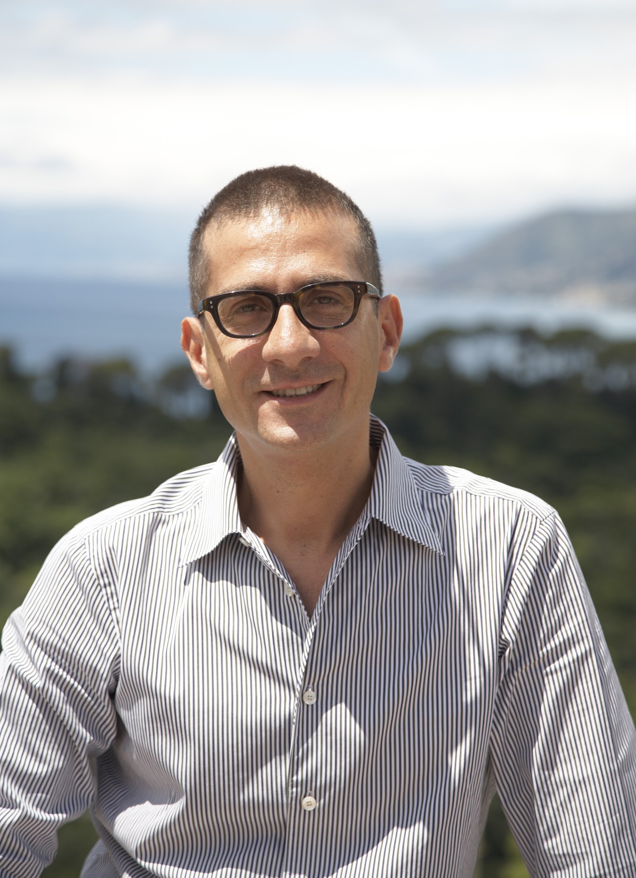 Mario Pietraccetta, owner of Villa Rosmarino, smiling at camera with Ligurian coast backdrop.