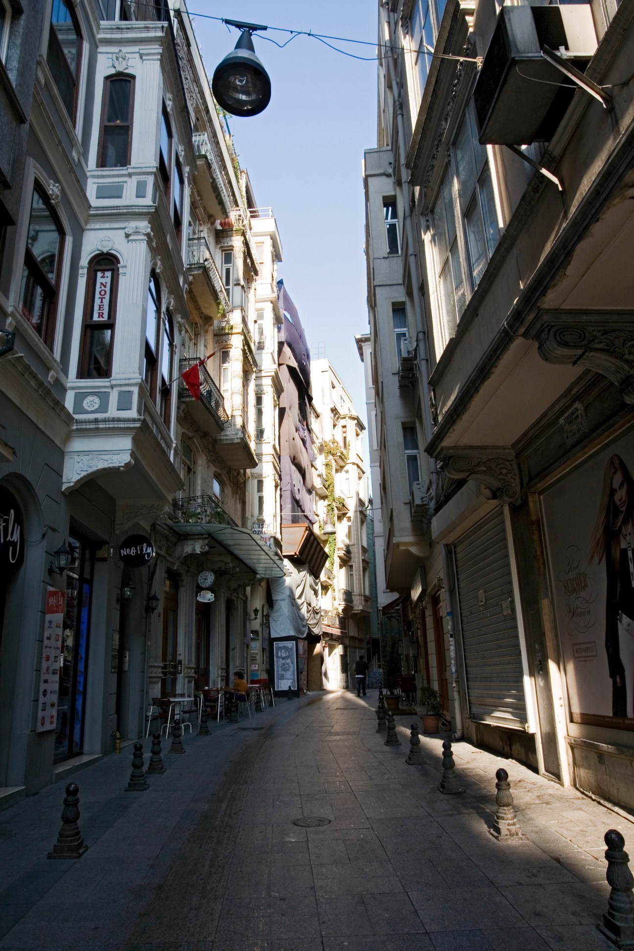 Narrow pedestrian street in Istanbul lined with historic buildings and ground-floor shops.
