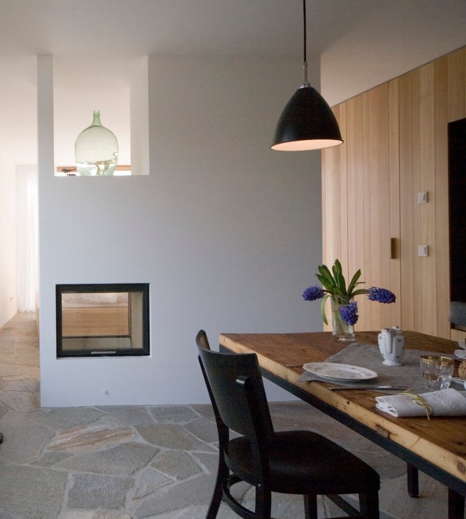 Modern dining room interior with wooden table, black pendant lamp, and wood-paneled walls at Aufberg 1113 lodge.