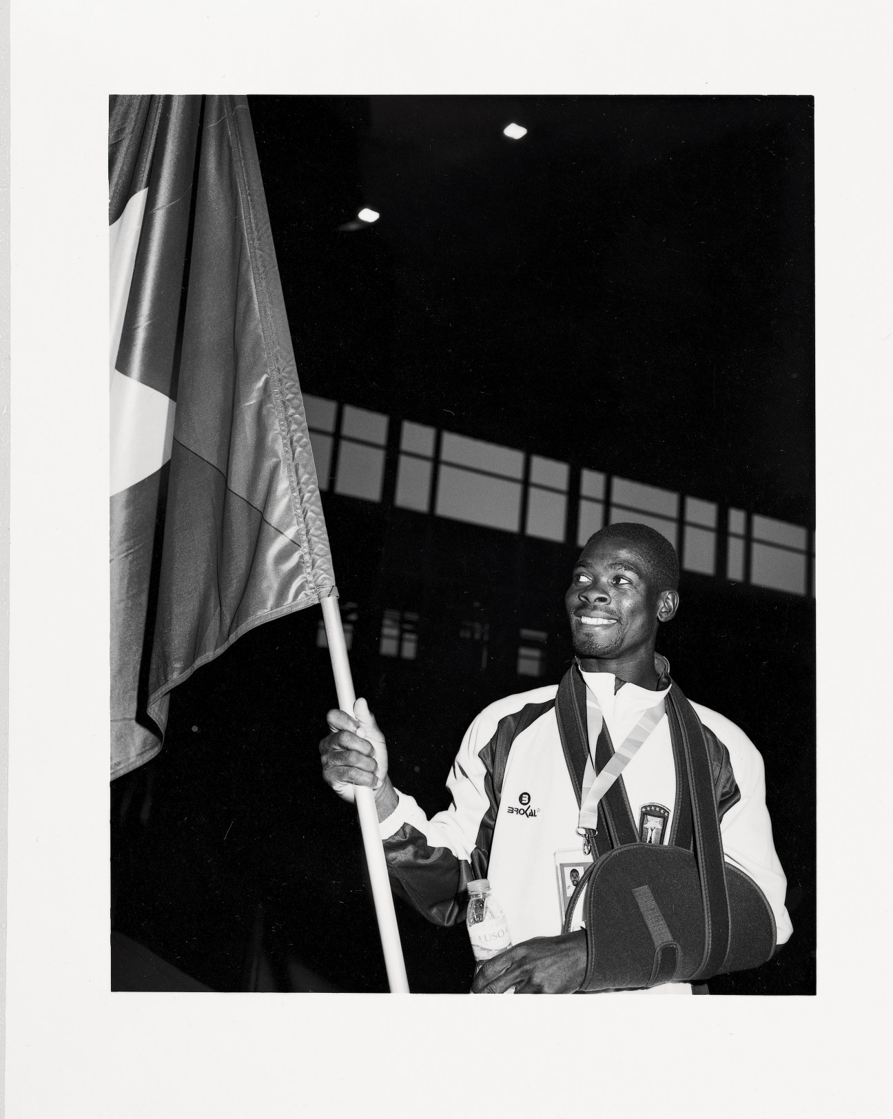 Guinea Bissau athlete holding national flag at opening ceremony