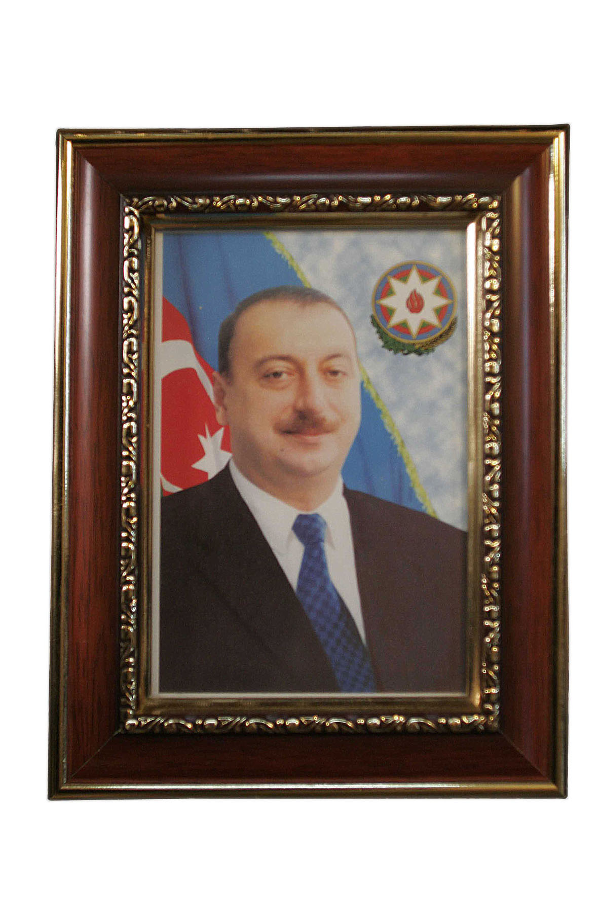 Framed portrait of President Ilham Aliyev in formal attire with Azerbaijani flag and national emblem behind him.