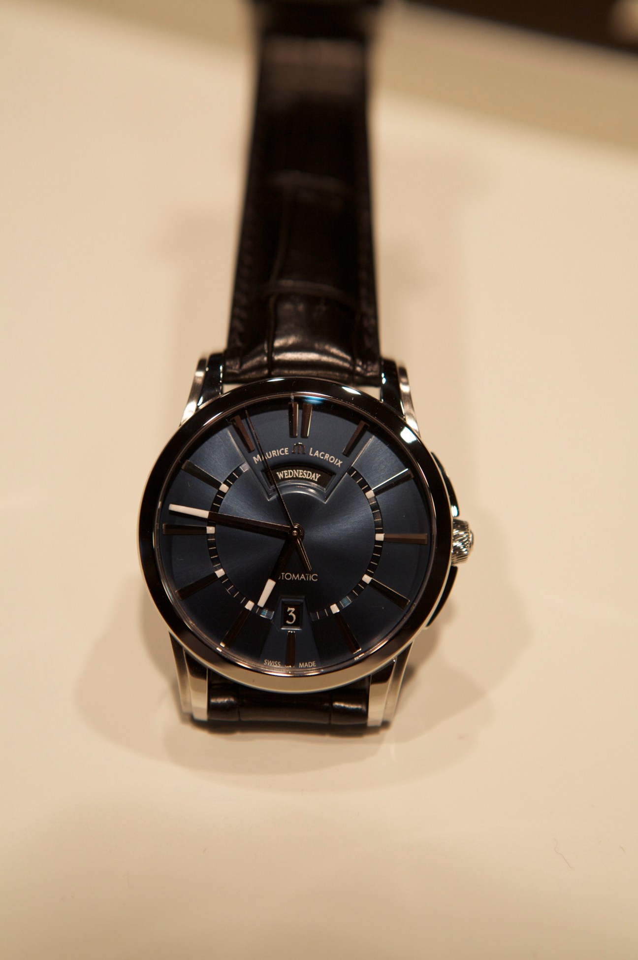 Maurice Lacroix Pontos Day Date watch with steel case, blue sunburst dial, and black leather strap.