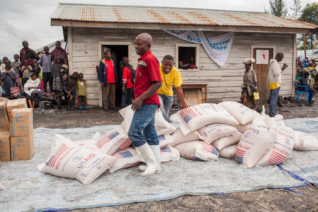 Aid workers distribute food aid sacks marked with American flags at a refugee camp in the Democratic Republic of Congo.