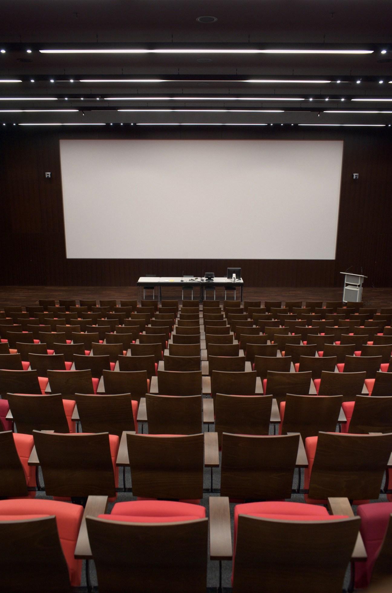 ECAL's auditorium with red and brown seats facing a projection screen and stage