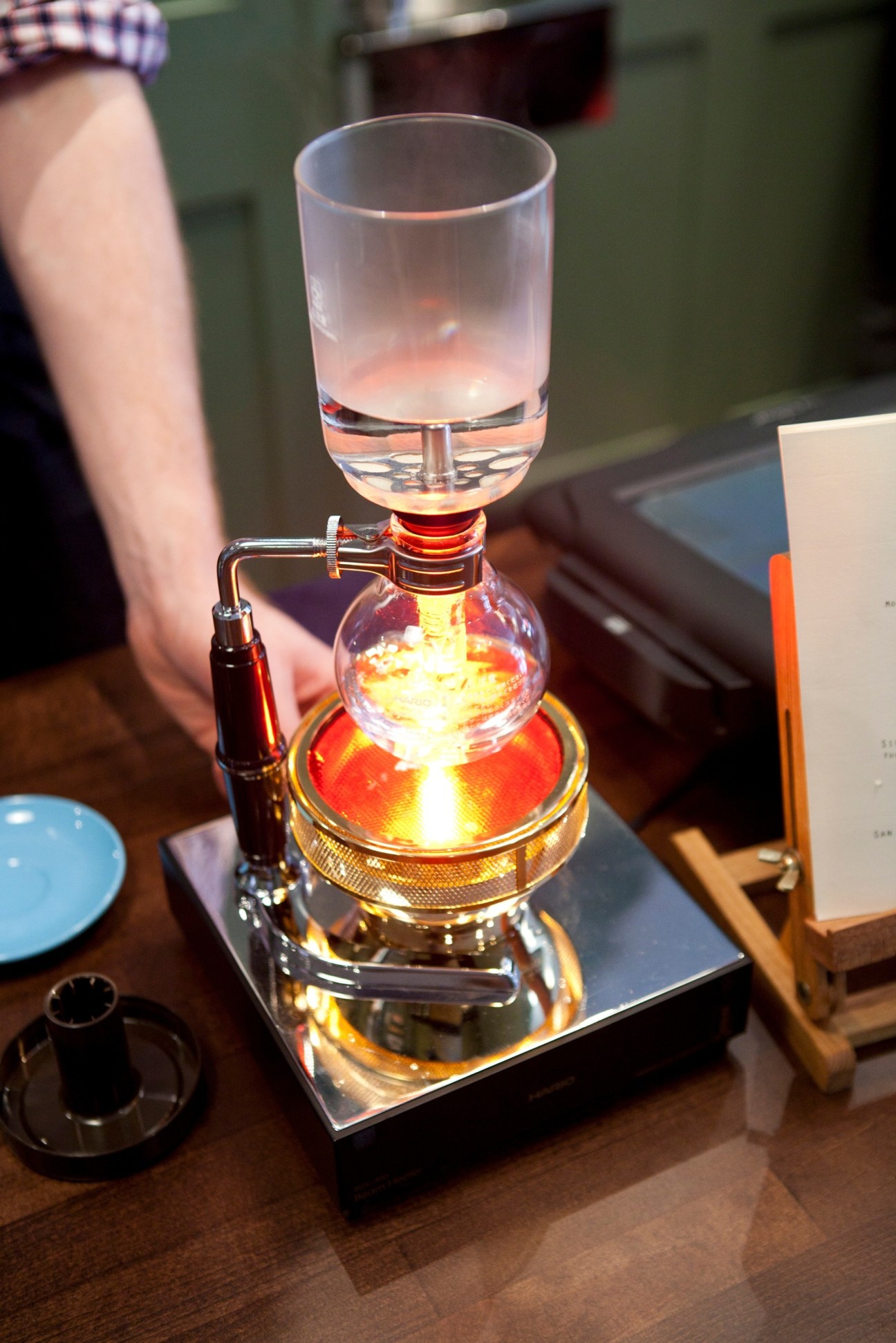 A Japanese Hario Syphon coffee machine with heated lamp base brewing filter coffee at Sensory Lab London.