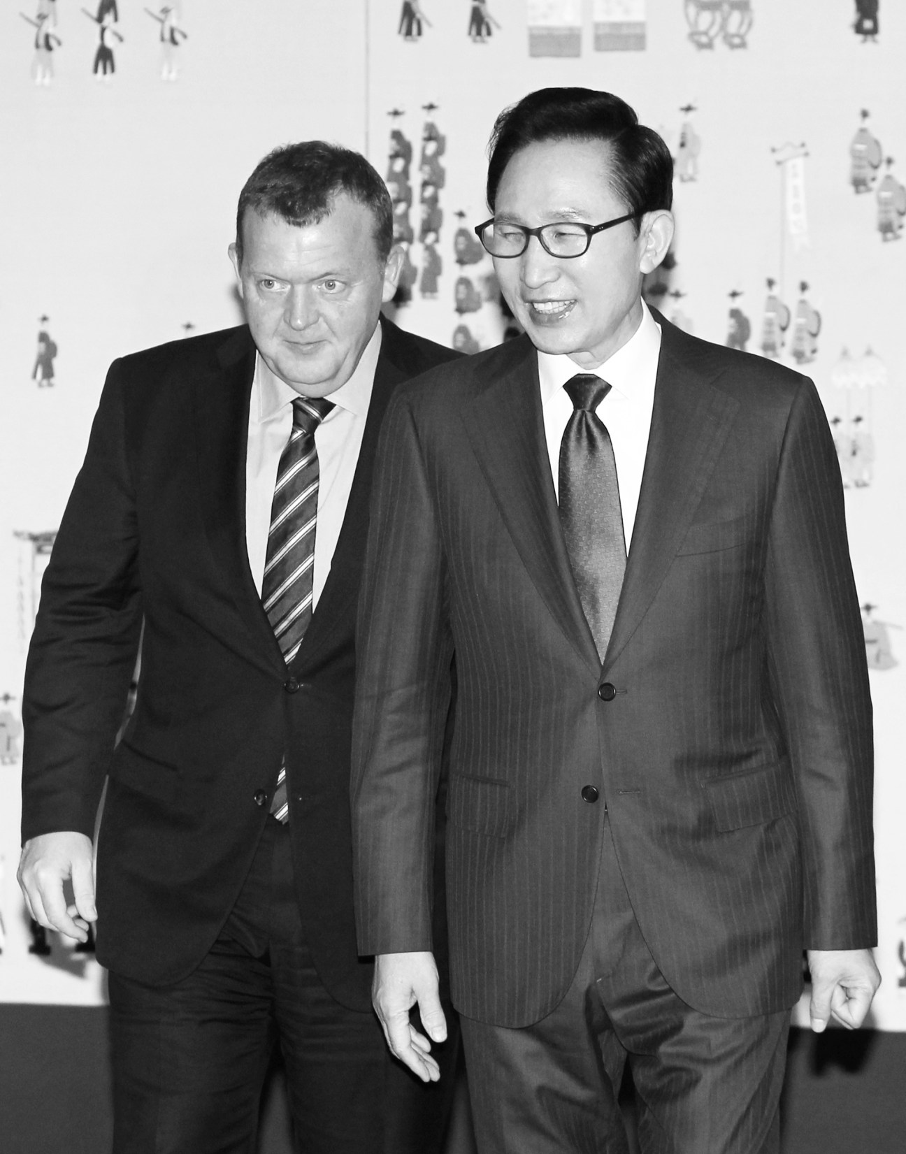 South Korean president Lee Myung-bak walks alongside another man in business suits.
