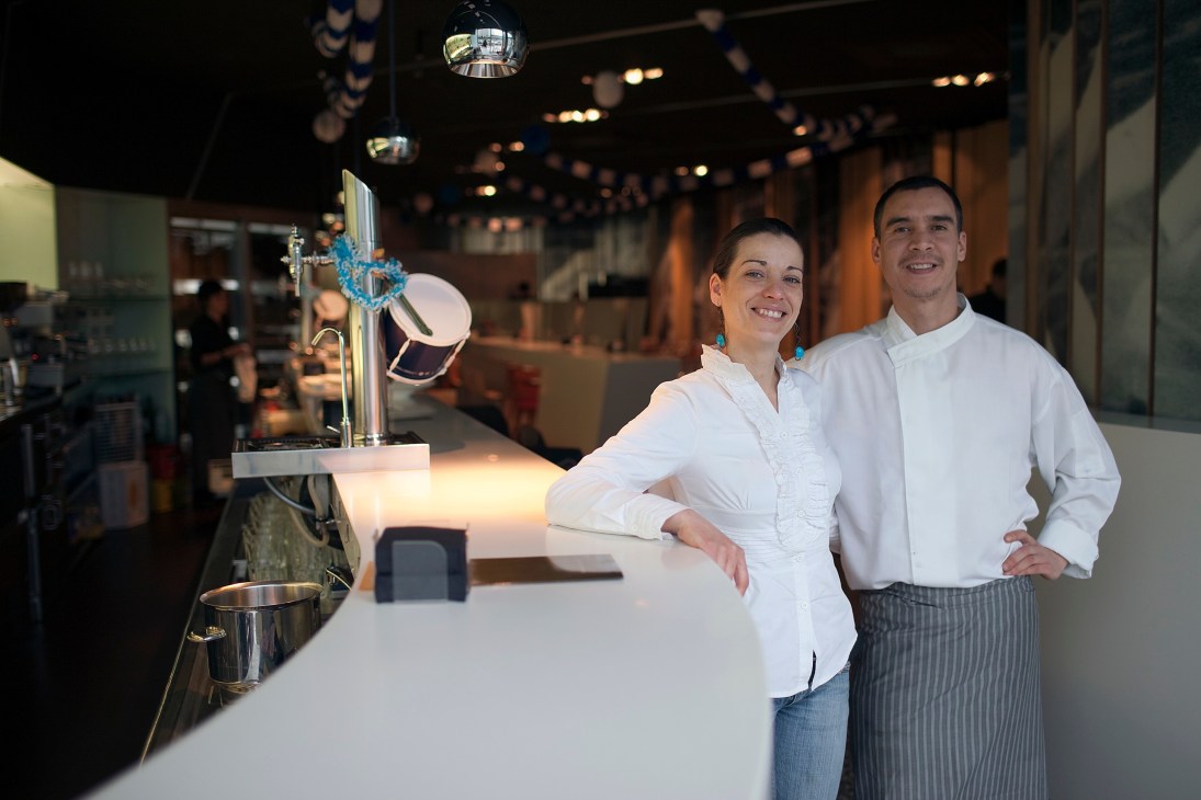 Carmen de Isla Torres and Eugenio Rafel Quijada stand behind a modern bar counter at Viento Sur restaurant.