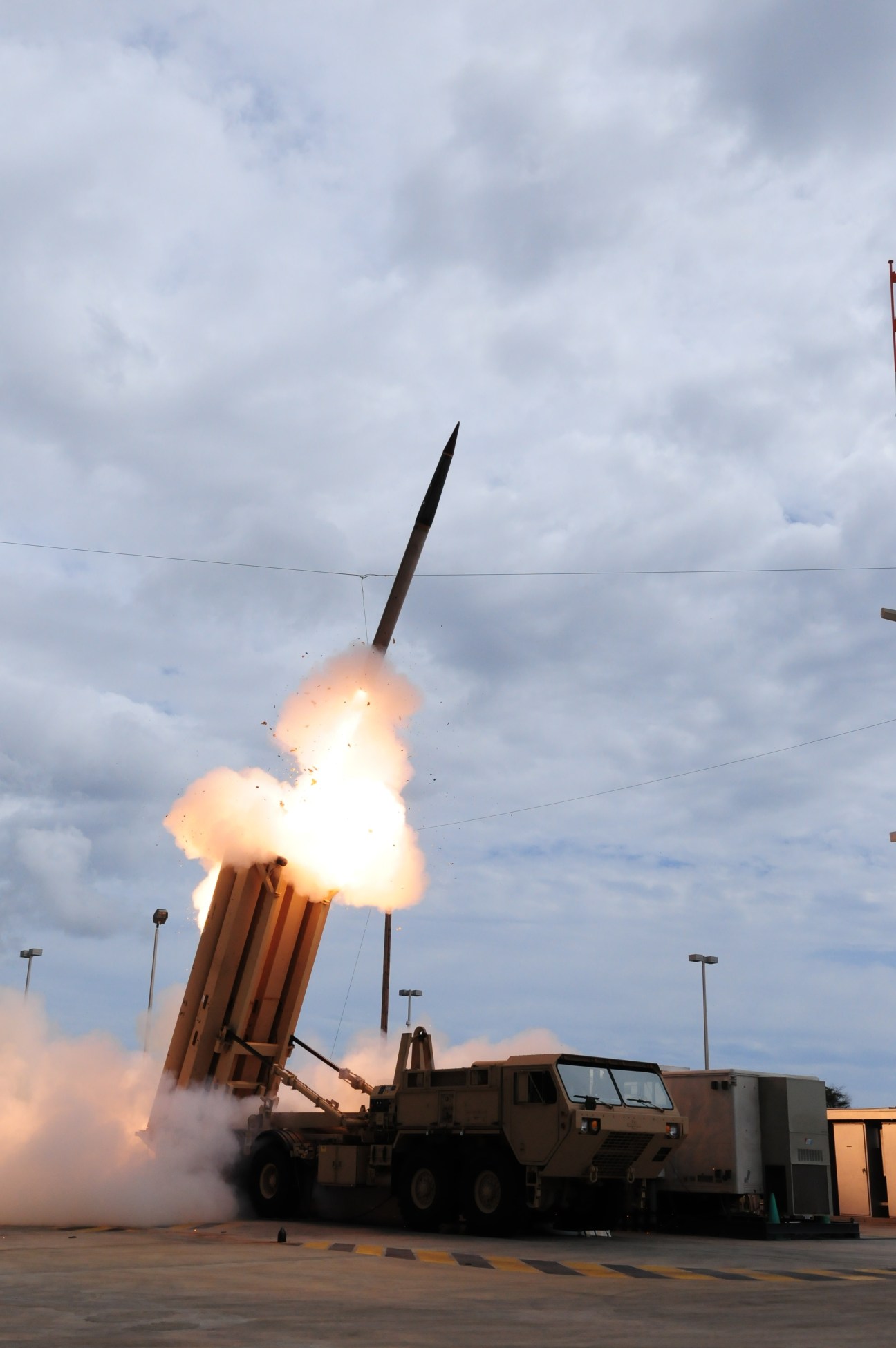 A THAAD ballistic missile defense system fires a missile into a cloudy sky during a test launch.