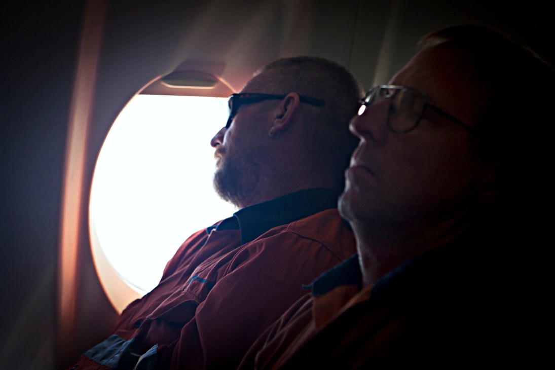Fly-in-fly-out workers sleep on an aircraft traveling to mining sites in Western Australia's Pilbara region.