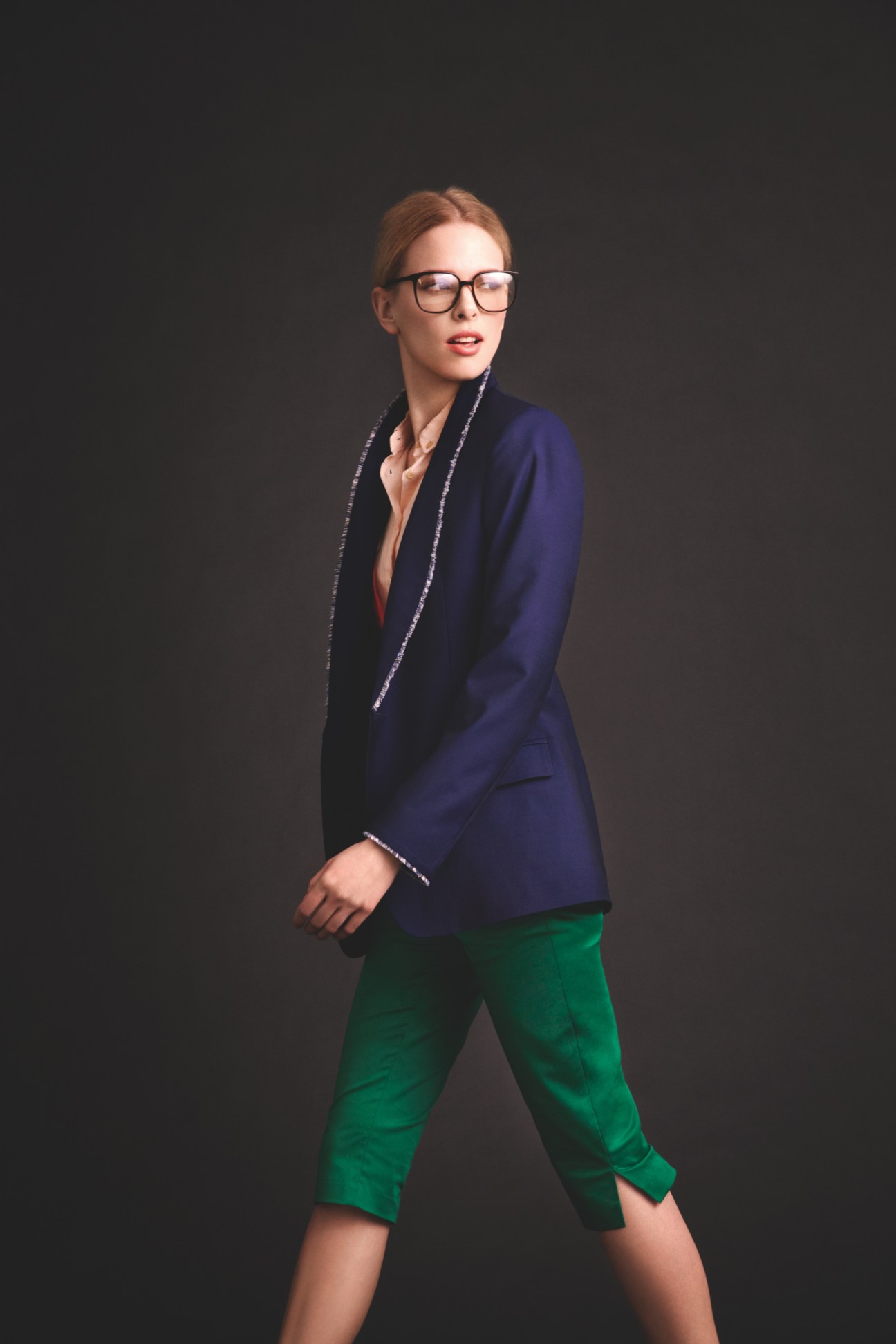 Model wearing Oliver Peoples glasses, 1205 jacket, Des Prés cardigan, Maison Kitsuné shirt, and Tomorrowland trousers in navy and green.
