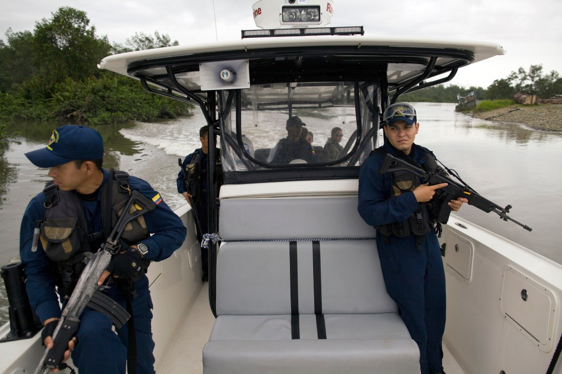 Colombian Navy and coast guard personnel patrol mangrove waters in an armed speedboat.