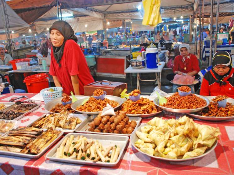 Women vendors selling halal food products at a covered market stall in Brunei.