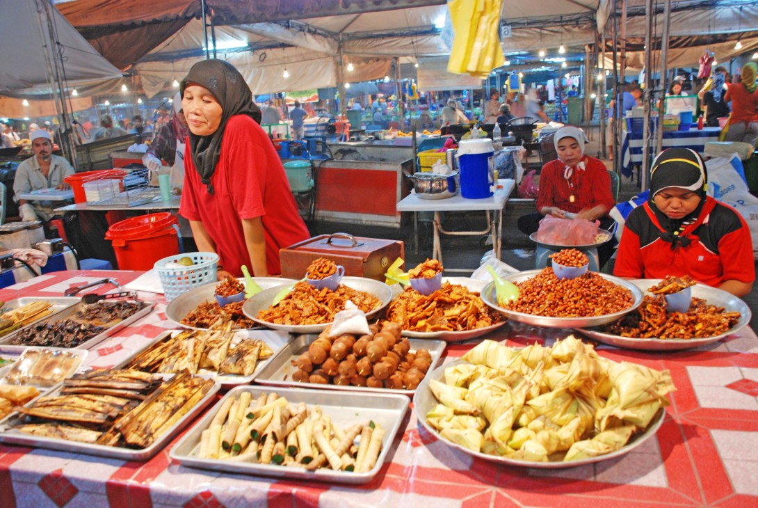 Women vendors selling halal food products at a covered market stall in Brunei.
