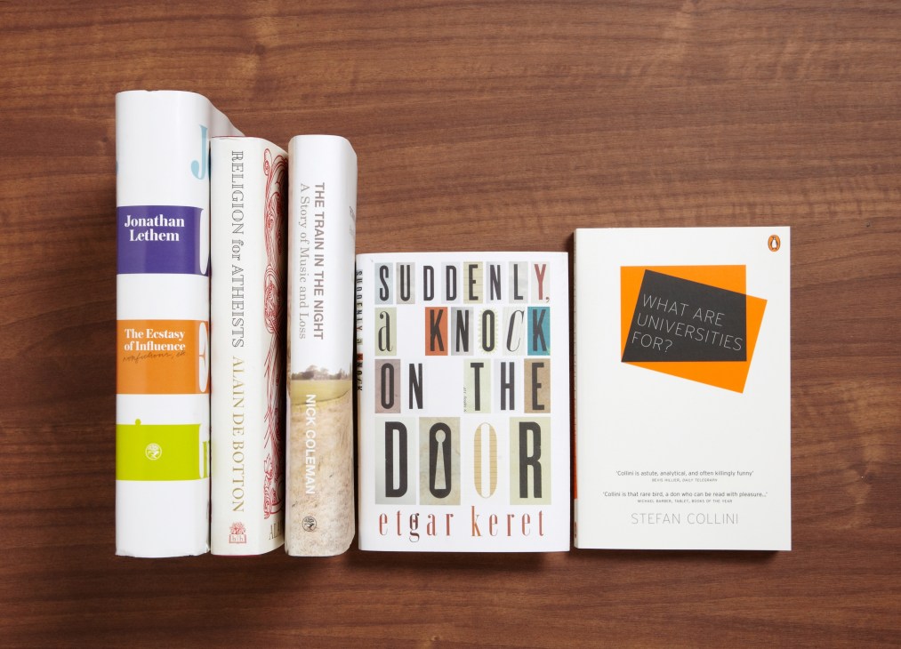 Five books arranged on a wooden surface: Jonathan Lethem's The Ecstasy of Influence, Religion for Atheists, The Train in the Night, Suddenly a Knock on the Door by Etgar Keret, and What are Universities for? by Stefan Collini.