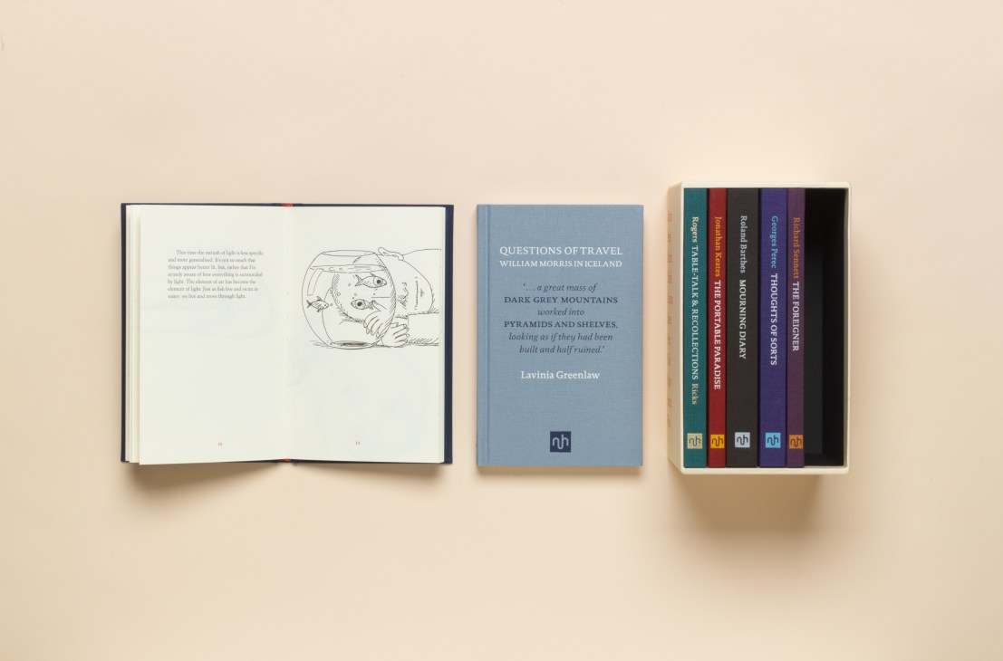 Three books displayed on a beige surface: an open sketchbook with line drawings, a blue book titled Questions of Travel by William Merton Icelaand, and a boxset of colorful spines from Notting Hill Editions.