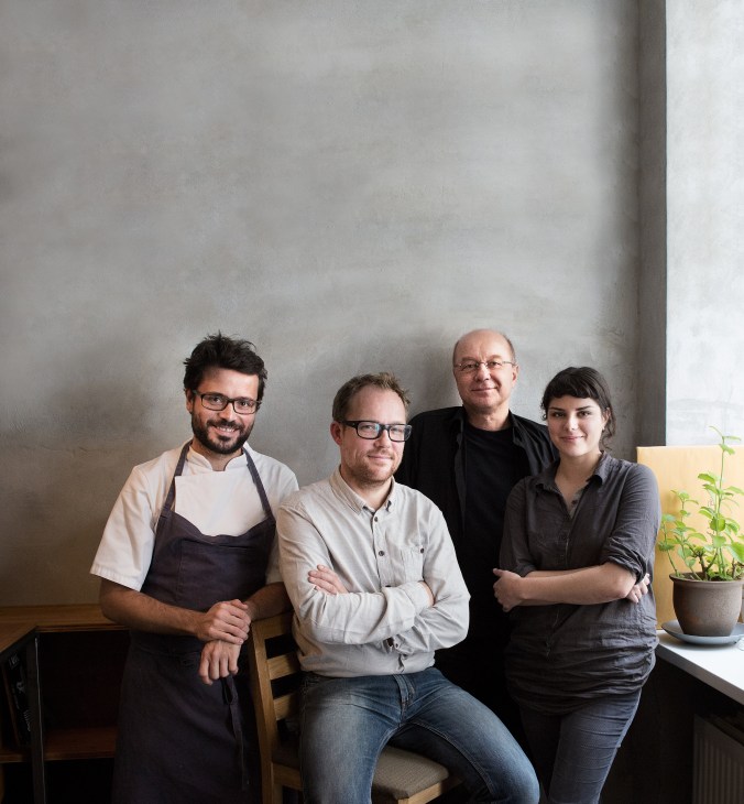 Four food experts standing against a white wall: Christian Puglisi, Søren Ejlerson, Tor Nørretranders, and a fourth panelist.