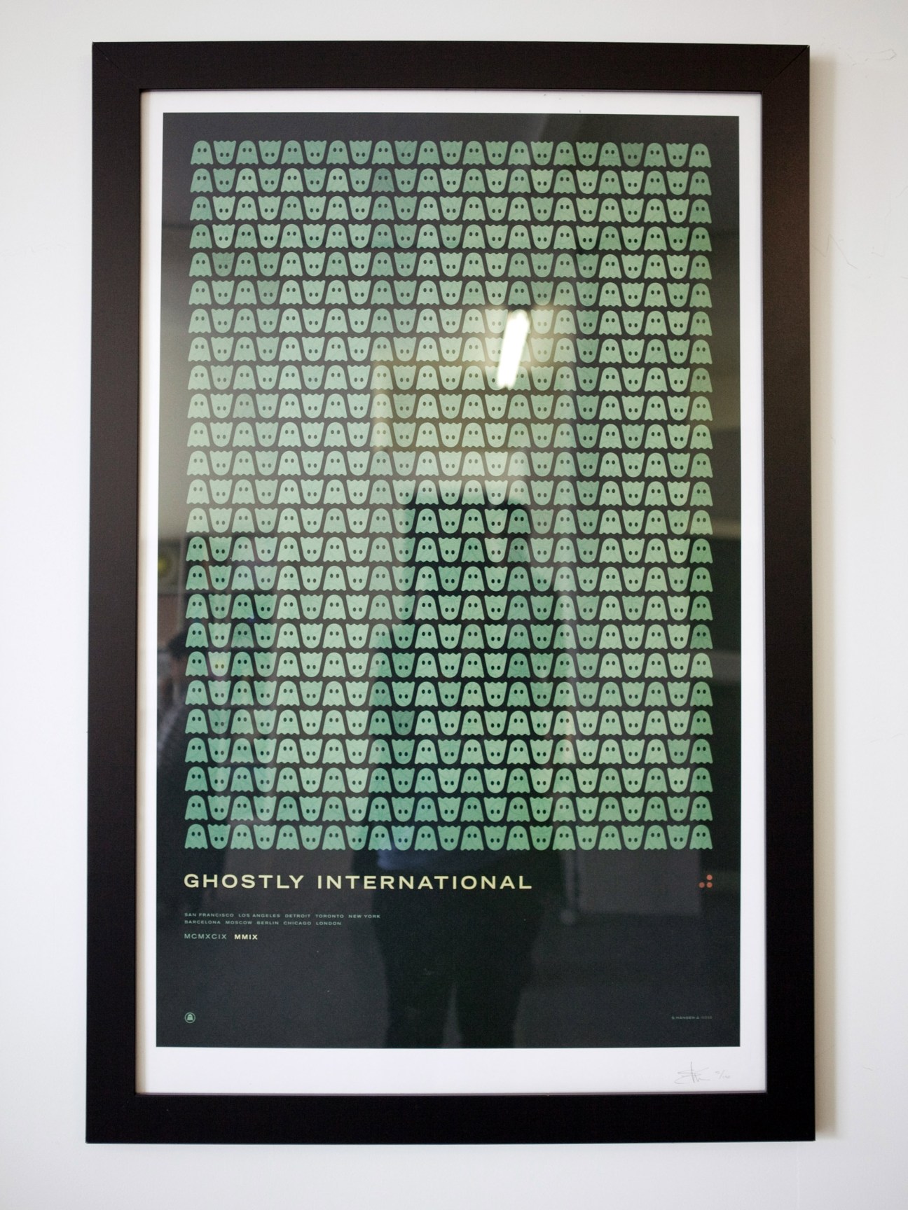 Framed 10th anniversary poster for Ghostly International by ISO50 featuring repeating green ghost motifs on dark background.