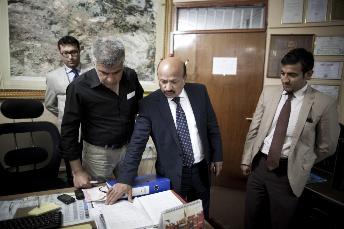 Mohammad Yunus Nawandish, Mayor of Kabul, stands at a desk with colleagues in an office.