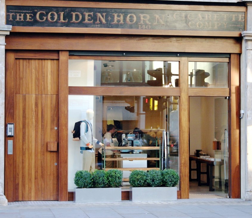 The storefront of Present retail concept in London's Shoreditch, featuring wooden facade and glass frontage with signage above.