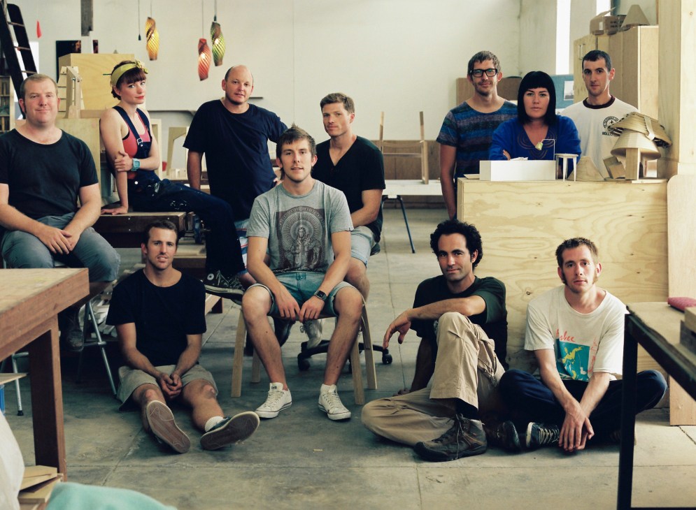 Group of furniture designers and craftspeople posed together in The Pattern Shop workshop.