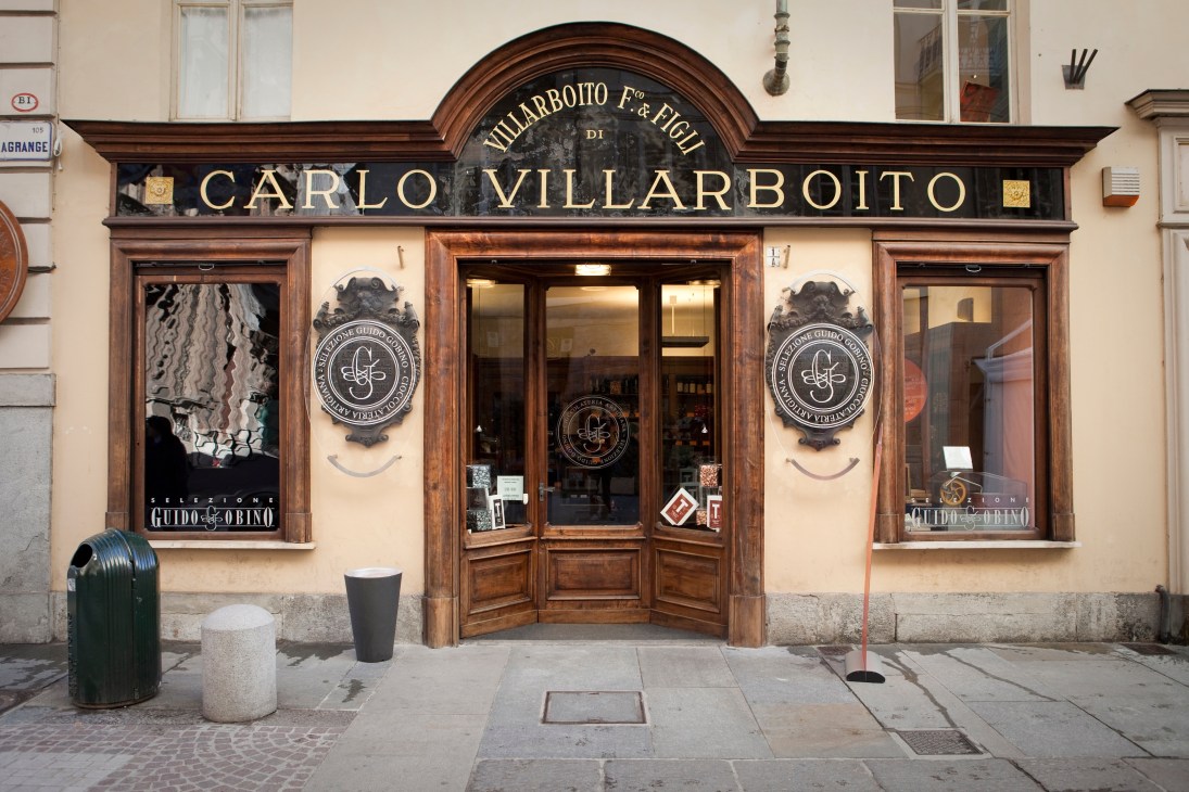 Historic storefront of Carlo Villarboito chocolatier with dark wood framing and cream-colored facade on Turin street.