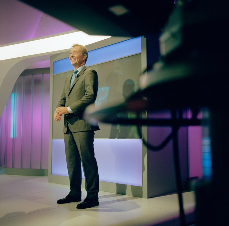 RTL Nederland news anchor Rick Nieman standing in a modern TV studio with colorful lighting