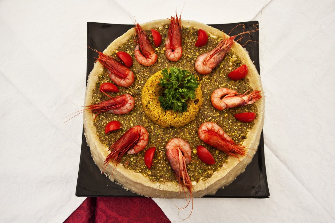 Fake cassata with swordfish and prawns topped with pistachio and garnished with red peppers and fresh parsley.