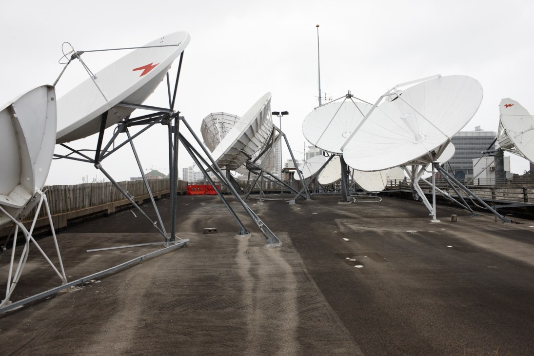 Multiple satellite dishes mounted on the rooftop of SBS headquarters in Sydney.