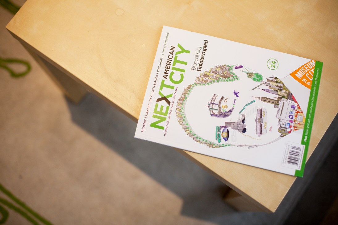 Next American City magazine Issue 24 displayed on a wooden surface with green spine and white cover featuring urban planning illustrations.